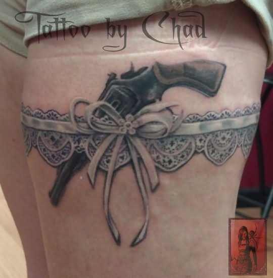 Grey Ink Gun And Garter Tattoo On Thigh