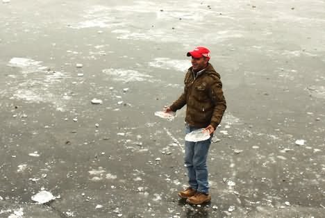 Man Standing On Frozen Dal Lake During Winters