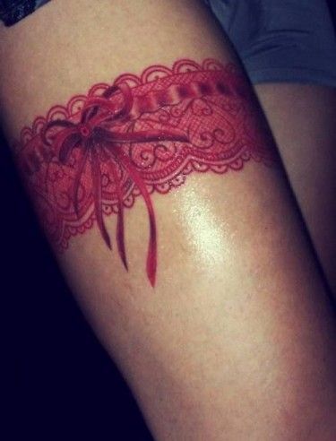 Red Ink Garter Tattoo On Thigh