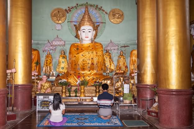 Worshipers Praying Inside A Prayer Hall At Shwedagon Pagoda