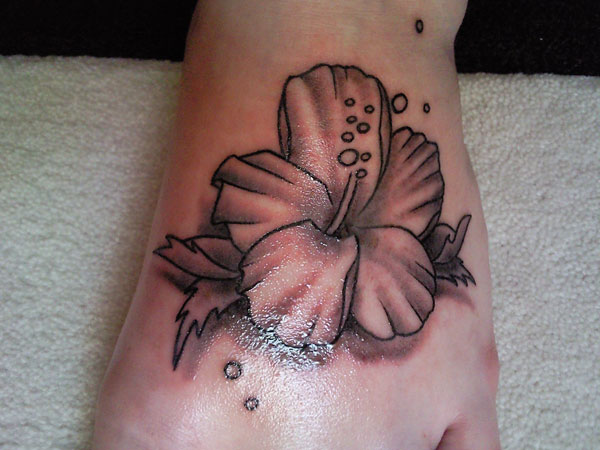 Black And White Hibiscus Tattoo On Left Foot