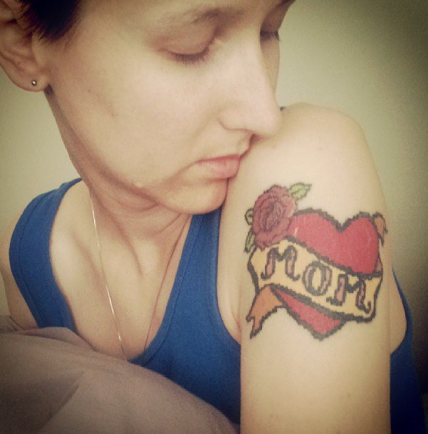 Cross Stitch Heart With Banner And Rose Tattoo On Girl Left Shoulder