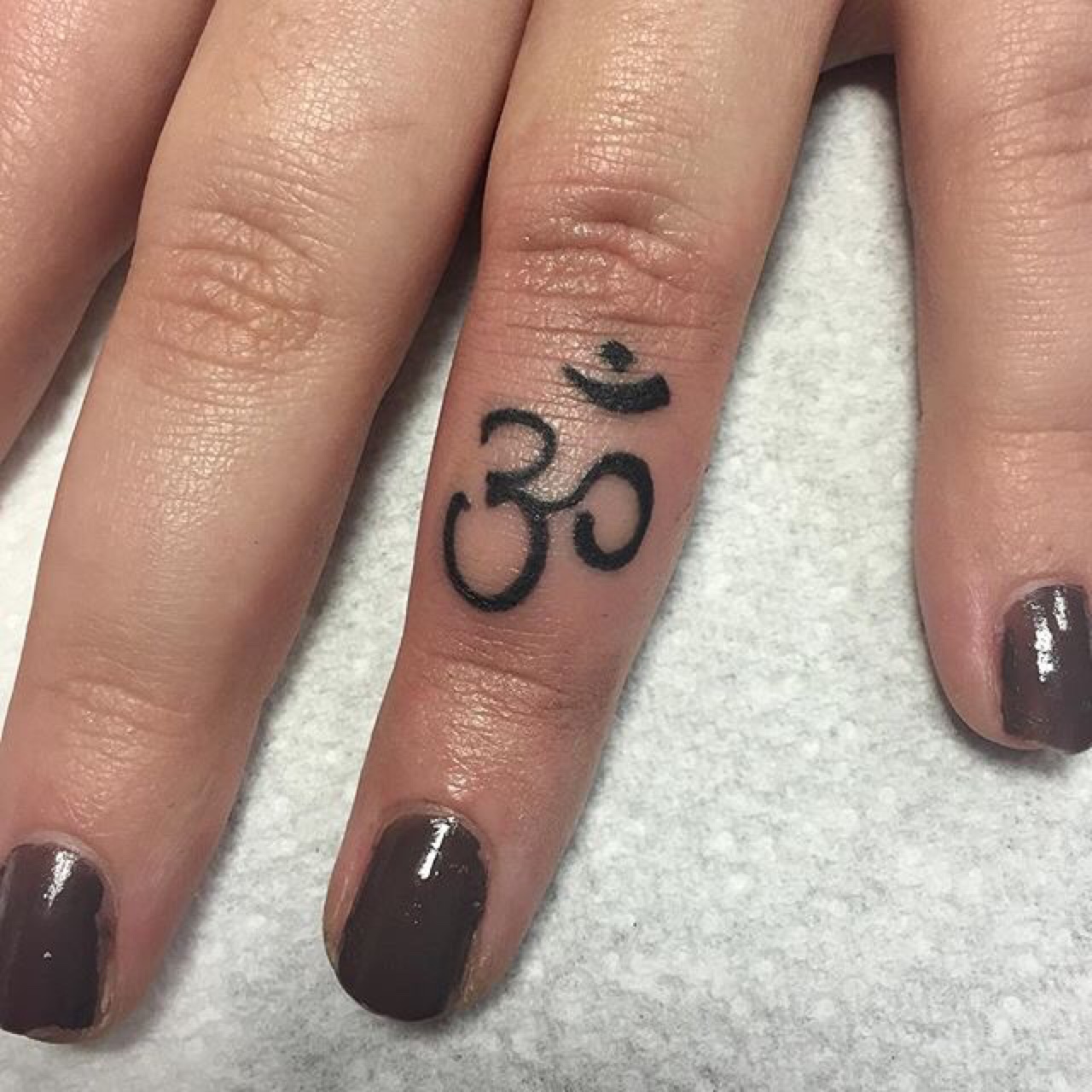 Om Symbol Tattoo On Girl Finger