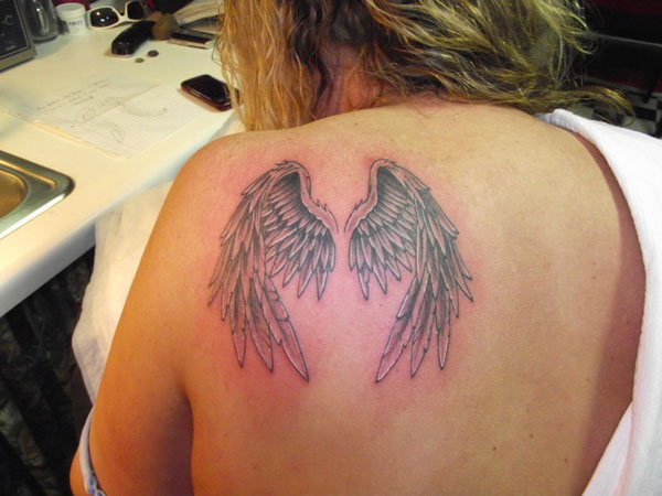 Black And Grey Wings Tattoo On Girl Upper Side Back