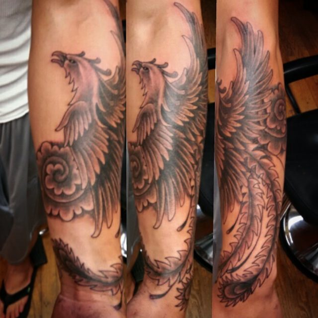 Black Ink Flying Phoenix Tattoo On Forearm