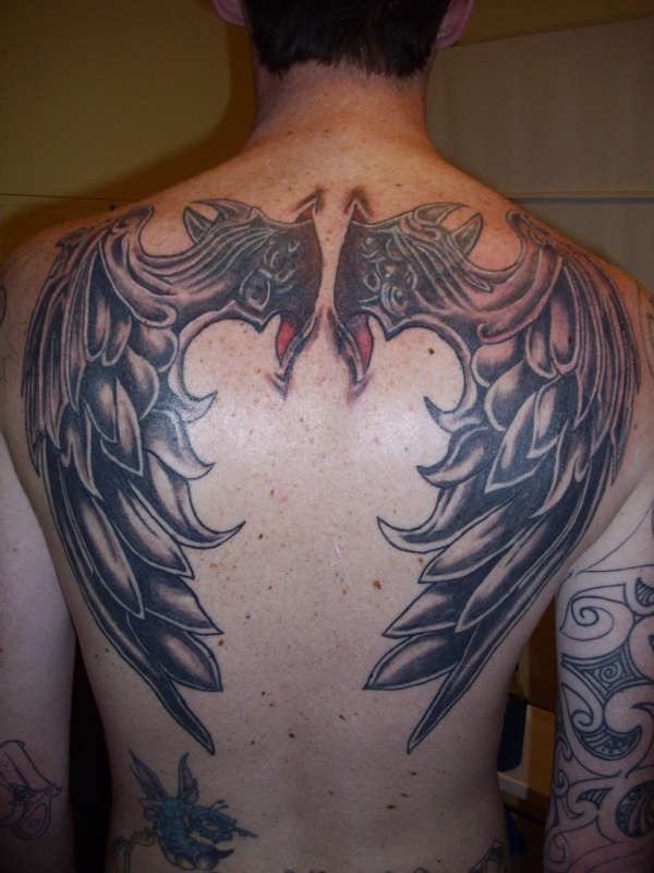 Black Ink Wings Tattoo On Man Upper Back