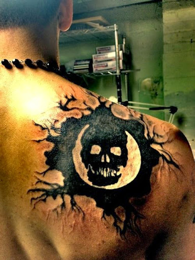 Black Skull Tattoo On Man Upper Side Back