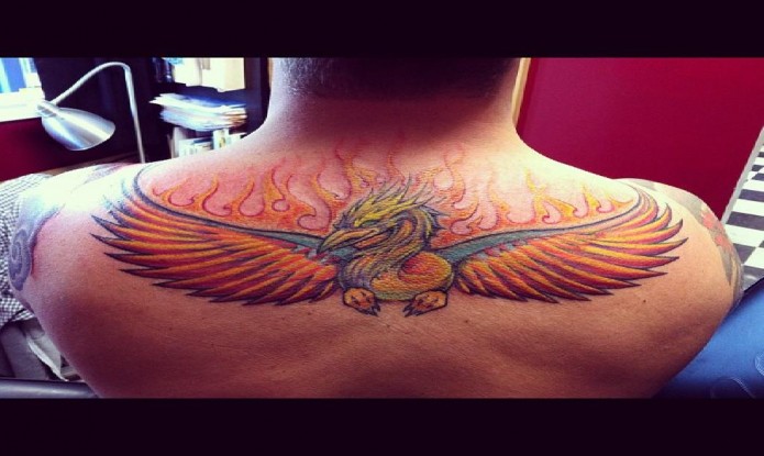 Colorful Rising Phoenix From The Ashes Tattoo On Man Upper Back