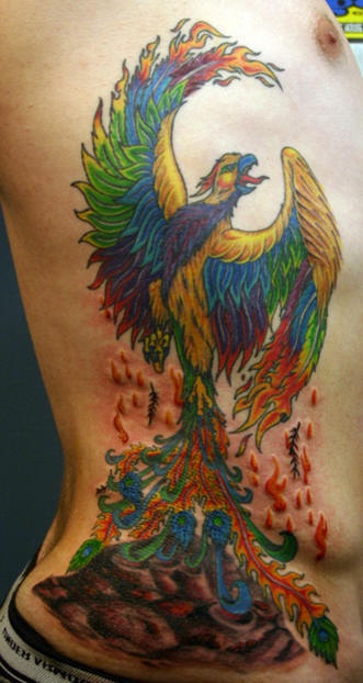 Colorful Rising Phoenix From The Ashes Tattoo On Side Rib