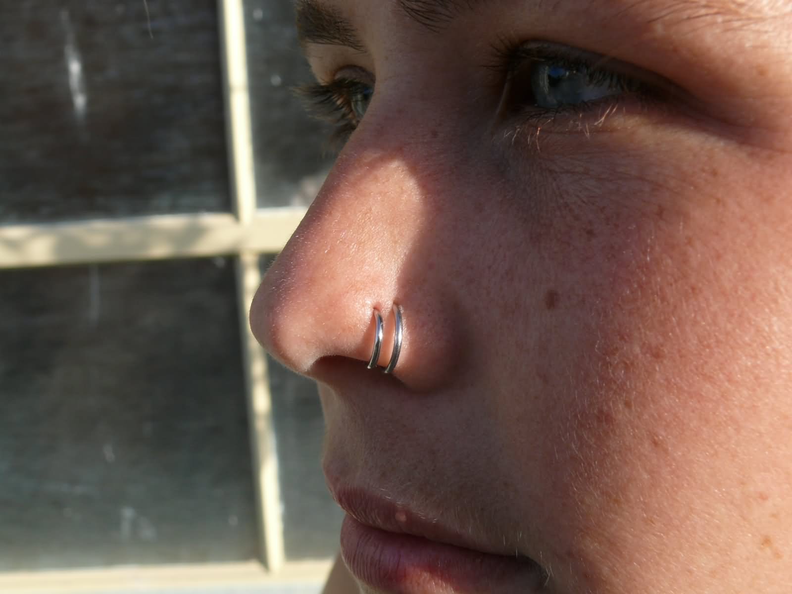 Double Nose Piercing With Silver Hoop Rings.