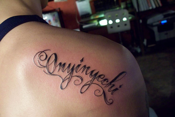 Onyinyechi Lettering Tattoo On Upper Right Back