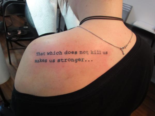 That Which Dose Not Kill Us Makes Us Stronger Quote Tattoo On Upper Side Back