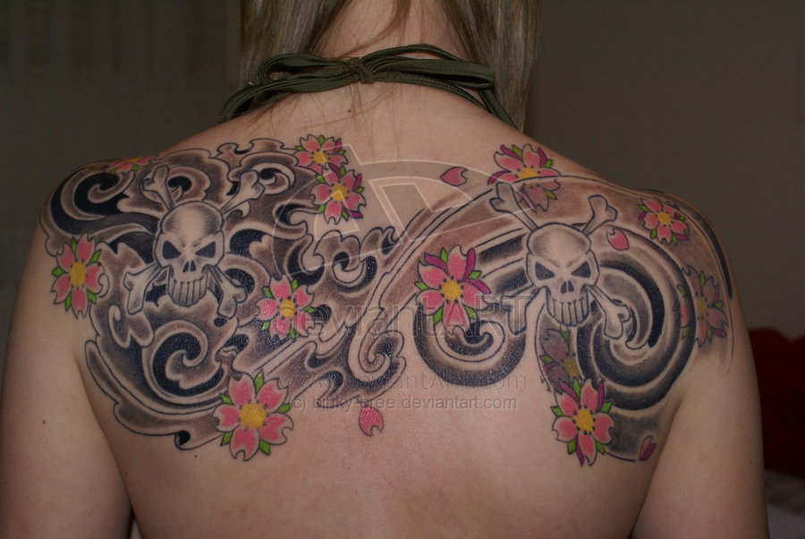 Two Danger Skulls With Flowers Tattoo On Girl Upper Back