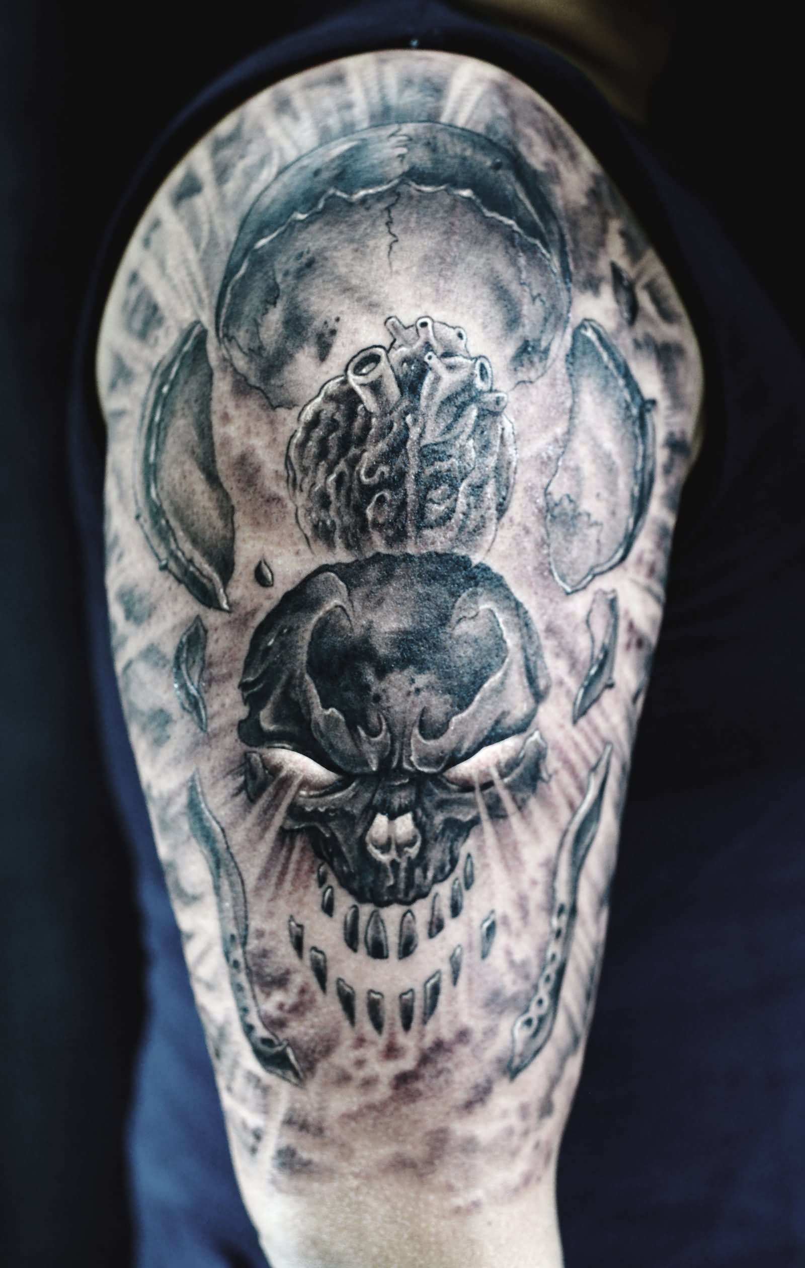 Black And Grey Skull With Real Heart Tattoo On Right Half Sleeve
