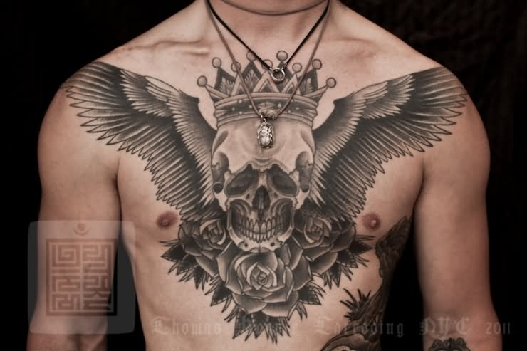 Black And Grey Skull With Wings And Roses Tattoo On Man Chest