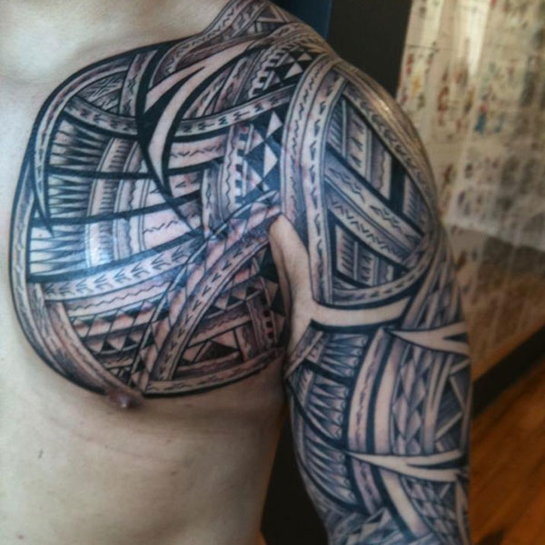 Black And Grey Tribal Tattoo On Chest And Half Sleeve