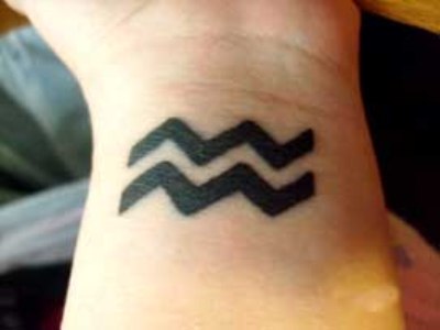 Black Aquarius Tattoo On Left Wrist