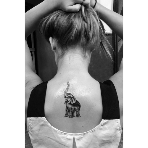 Black Ink Elephant Trunk Up Tattoo On Girl Upper Back