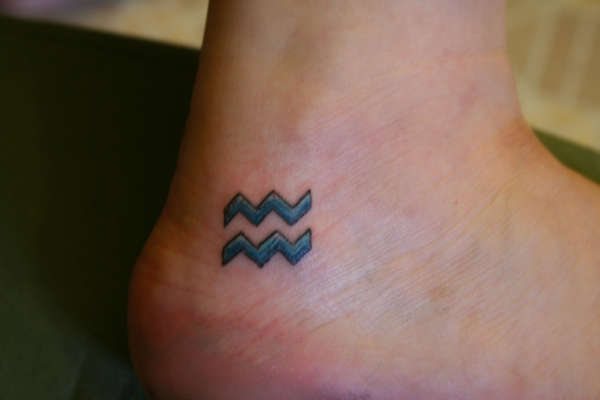 Blue Ink Aquarius Tattoo On Ankle