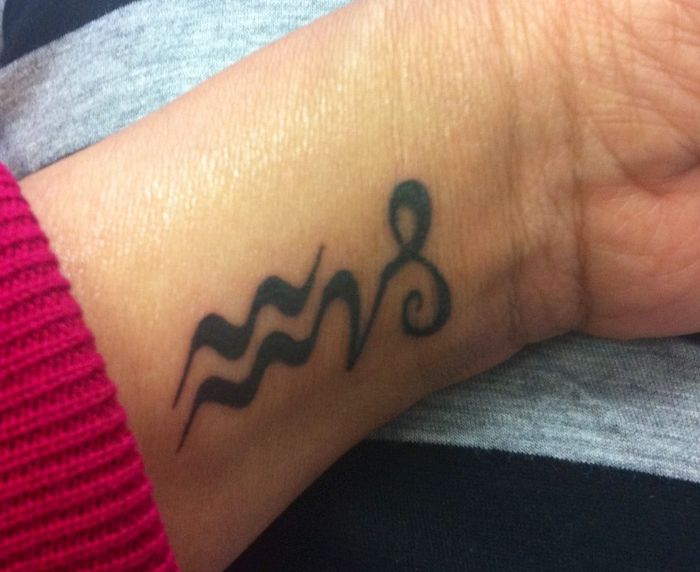 Cute Black Tribal Aquarius Tattoo On Left Wrist