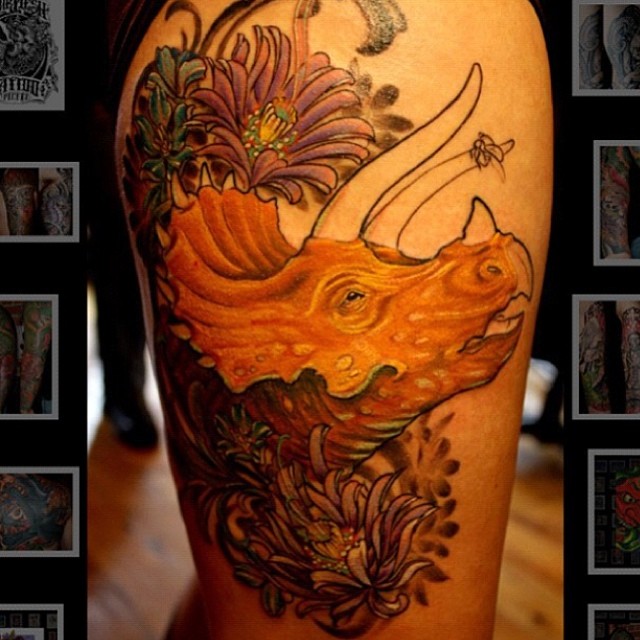 Flowers And Dinosaur Head Tattoo On Thigh