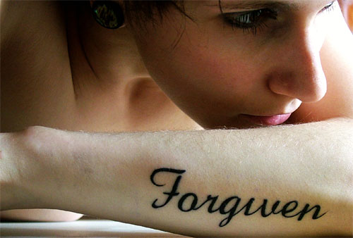 Forgiven Word Tattoo On Girl Left Forearm
