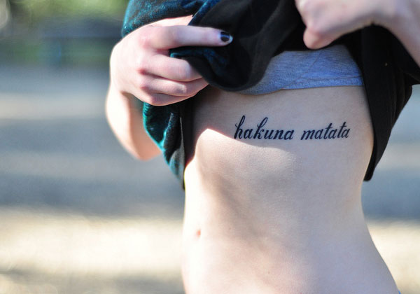 Hakuna Matata Lettering Tattoo On Girl Side Rib