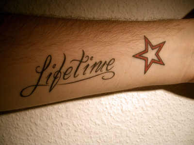 Lifetime Word With Star Tattoo On Left Forearm