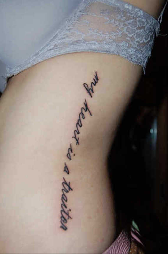 My Heart Is A Traitor Quote Tattoo On Girl Side Rib