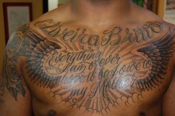 Quote With Clouds And Wings Tattoo On Man Chest