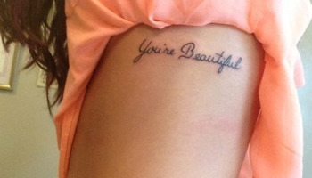 You're Beautiful Quote Tattoo On Girl Side Rib
