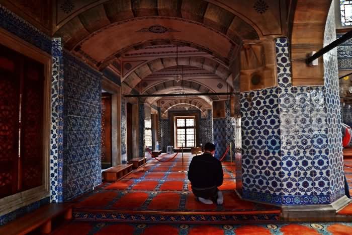 A Man Praying Inside The Rustem Pasha Mosque In Istanbul