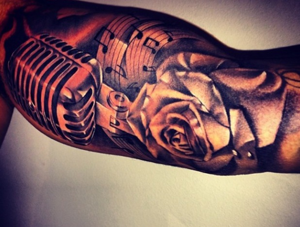 Dark Grey Ink Rose Flower And Microphone Tattoo On Bicep