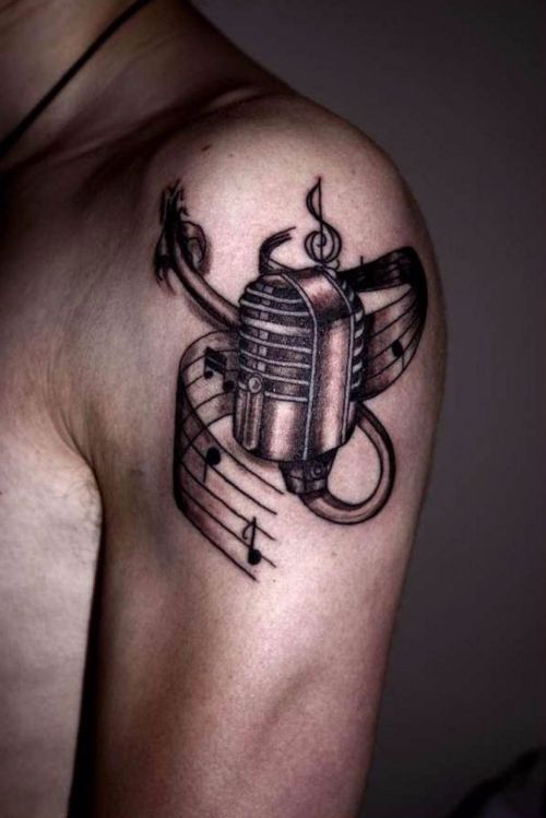 Grey Ink Music Notes And Microphone Tattoo On Left Shoulder