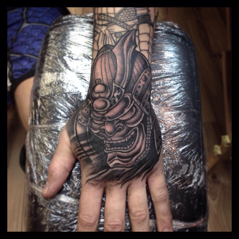 Grey Ink Samurai Tattoo On Left Hand by Paul Priestley
