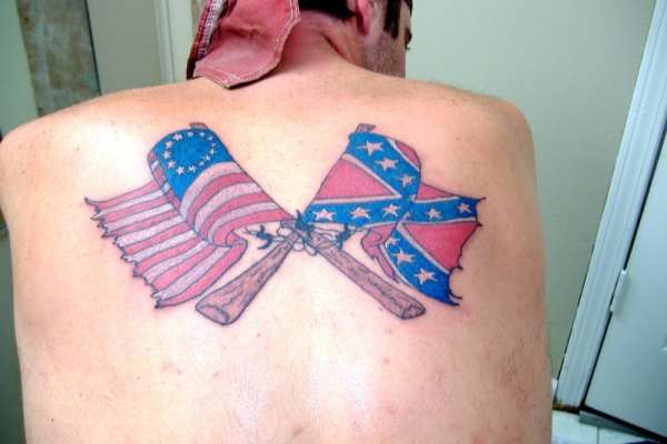 Two Crossing Rebel And USA Flag Tattoo On Man Upper Back