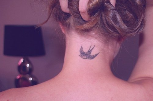 Black And Grey Flying Bird Tattoo On Girl Back Neck