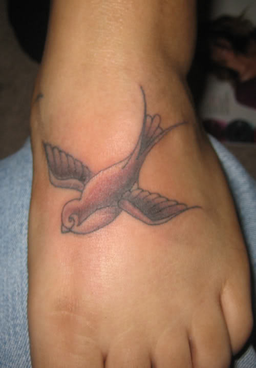 Black Ink Bird Tattoo On Left Foot