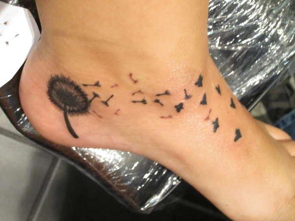 Black Ink Dandelion With Flying Birds Tattoo On Left Foot
