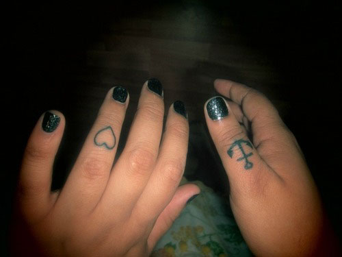 Black Outline Heart And Anchor Tattoo On Girl Finger