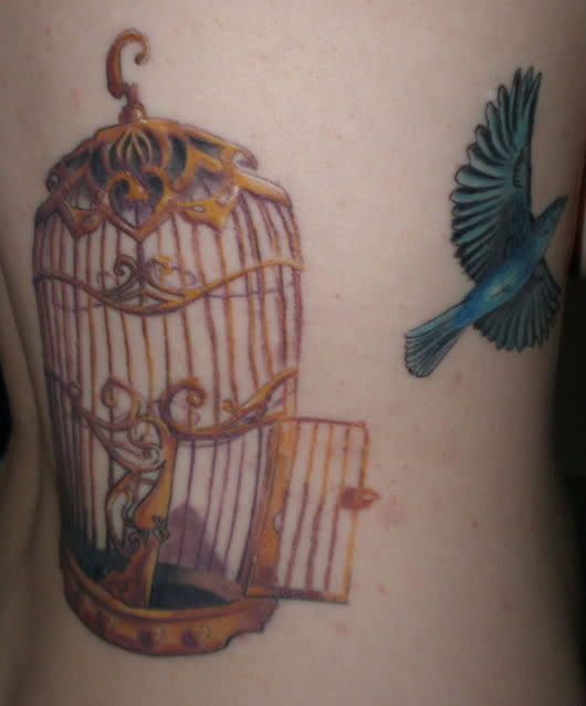 Blue Ink Flying Bird And Cage Tattoo On Side Rib
