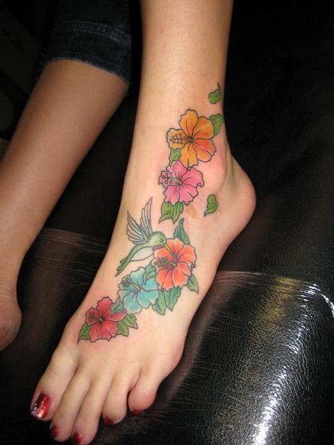 Colorful Flowers With Flying Bird Tattoo On Girl Left Foot