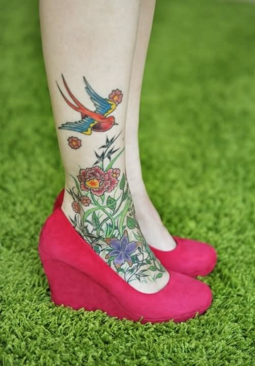 Colorful Flying Bird With Flowers Tattoo On Girl Right Foot