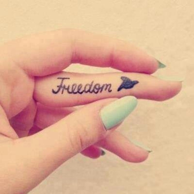 Freedom Lettering With Flying Bird Tattoo On Girl Finger