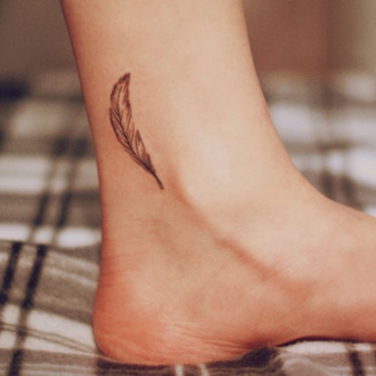 Grey Ink Feather Tattoo On Ankle