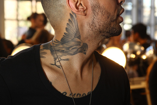 Grey Ink Flying Bird Tattoo On Man Side Neck