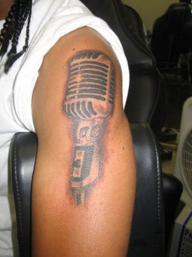Grey Ink Mic With Music Notes Tattoo On Left Shoulder