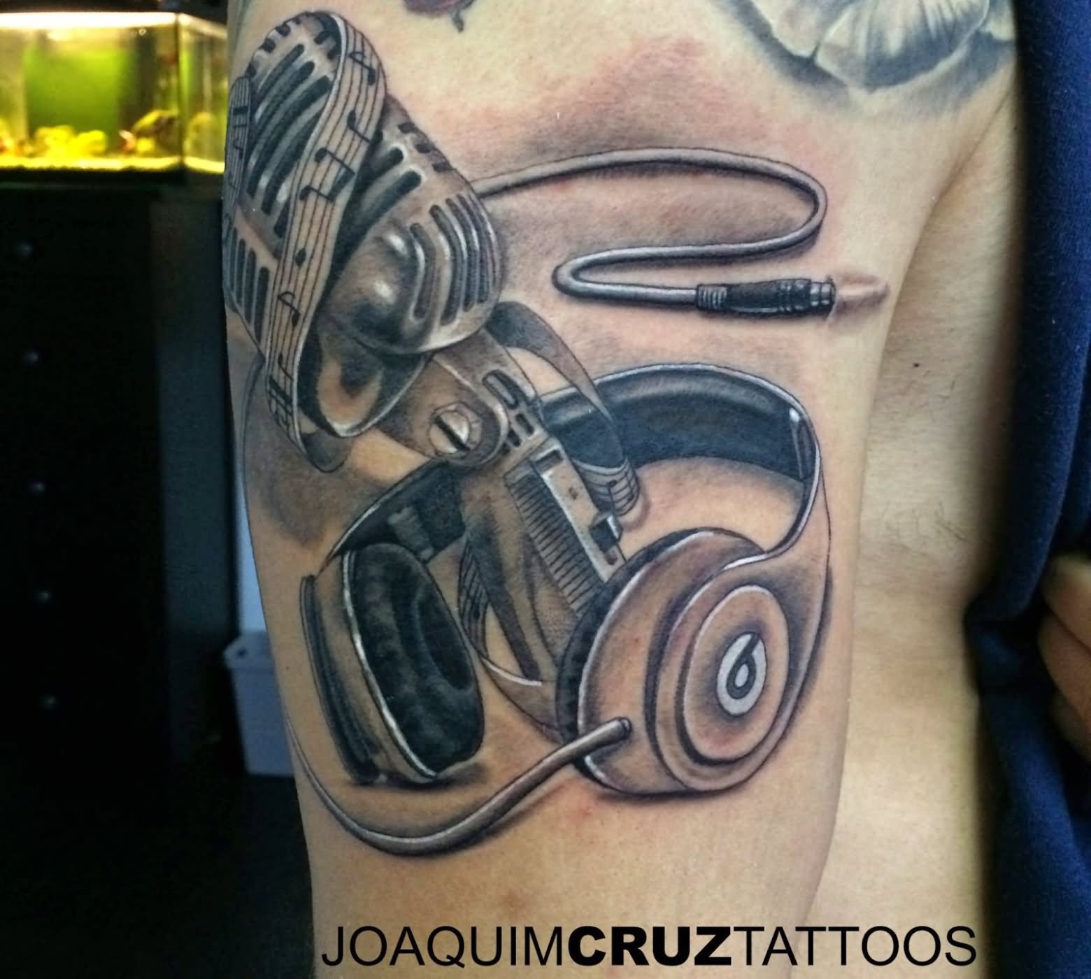 Grey Ink Microphone And Headphone Tattoo On Right Bicep