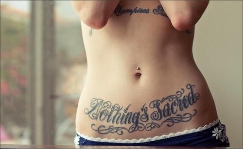 Nothing Sacred Lettering Tattoo On Girl Stomach