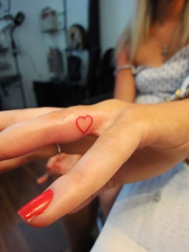 Red Outline Heart Tattoo On Girl Finger